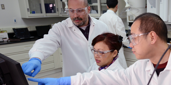 scientists clustered in front of a computer