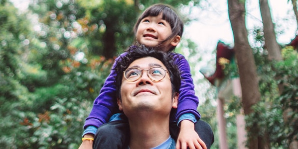 man with girl on shoulders